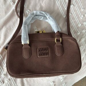Designer inspired brown suede bad fashion forward. With crossbody strap.